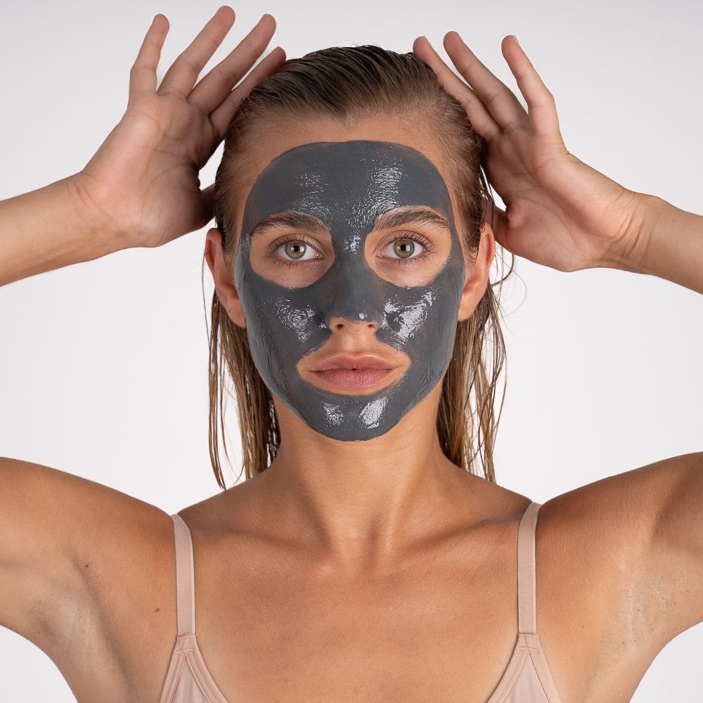 femme avec le masque charbon pureté sur le visage