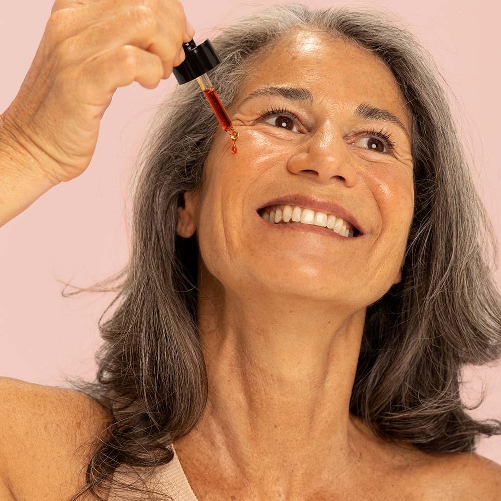 Femme qui s'applique le serum intense éclat anti age anti tache