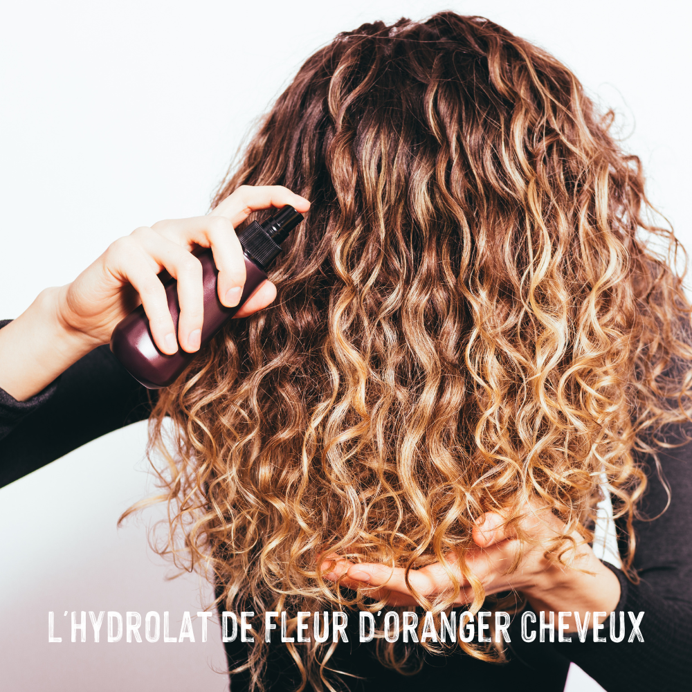 Femme qui utilise l'hydrolat de fleur d'oranger sur ses cheveux